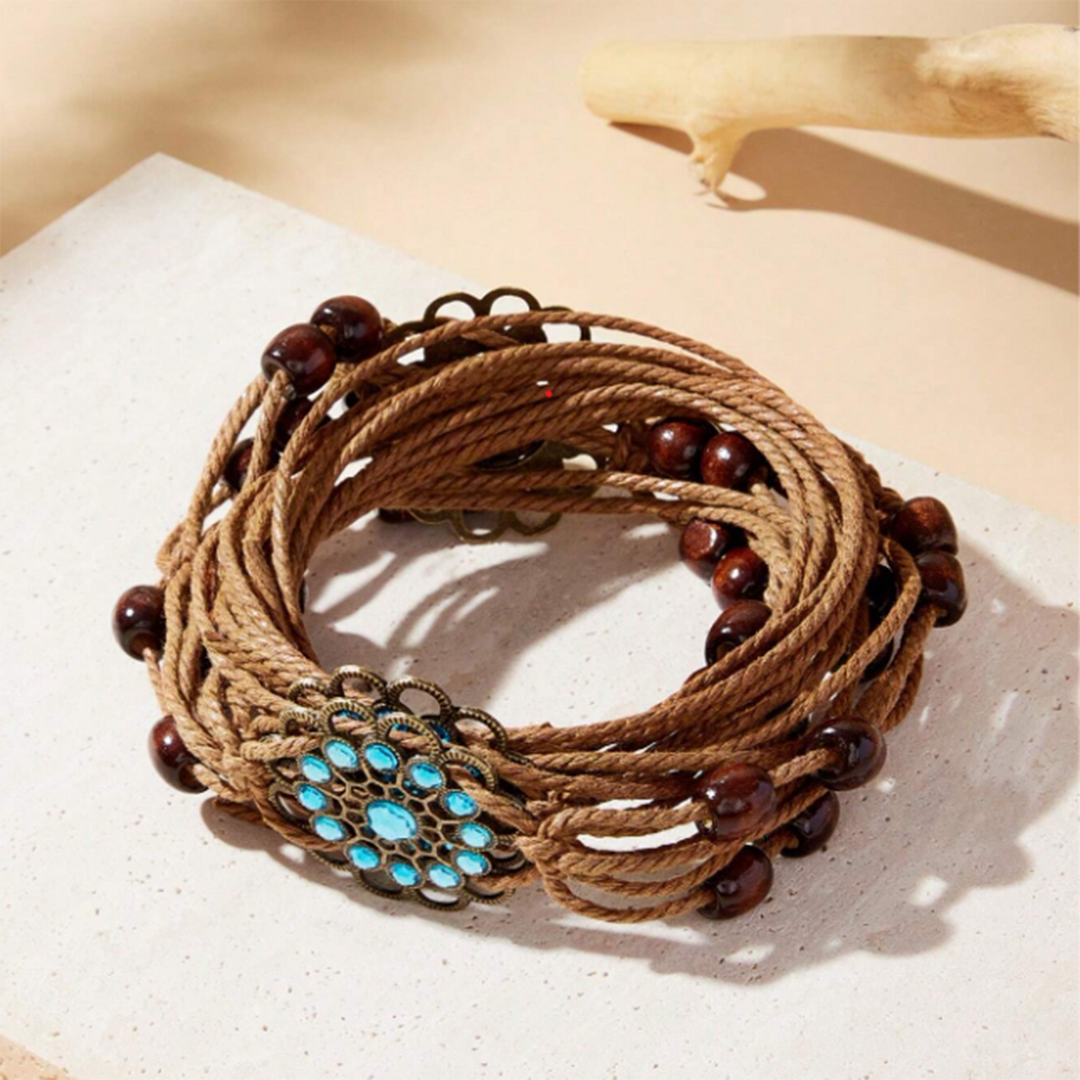 A brown macrame belt with floral accents, displayed on a neutral background.