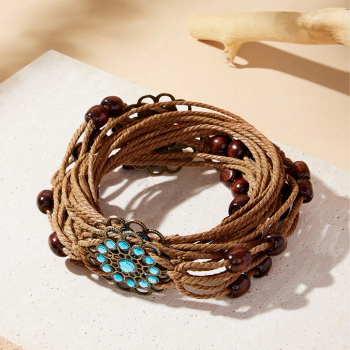 A brown macrame belt with floral accents, displayed on a neutral background.