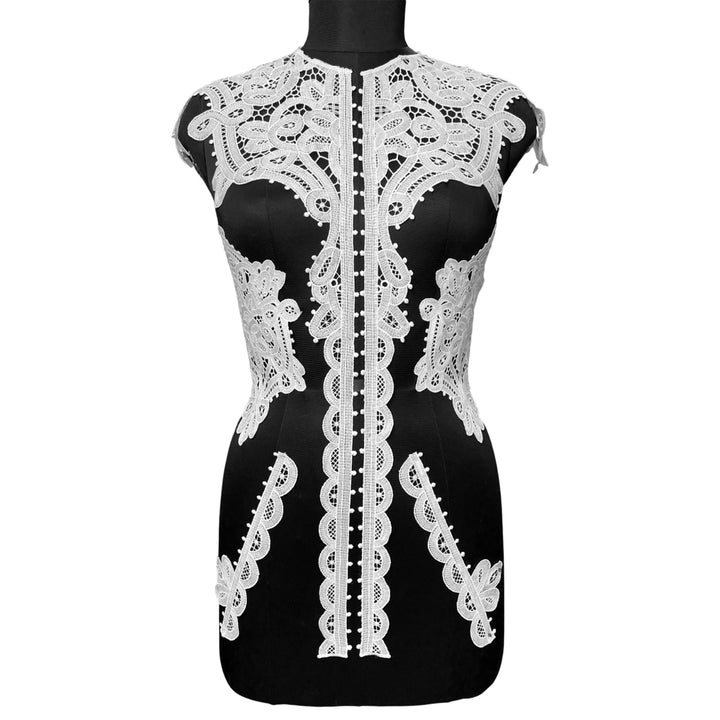 Black dress with white lace detailing on a mannequin against a white background