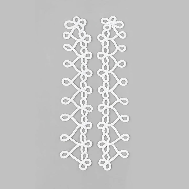 Two white decorative lace applique strips with an intricate looped pattern, displayed vertically on a solid gray background.