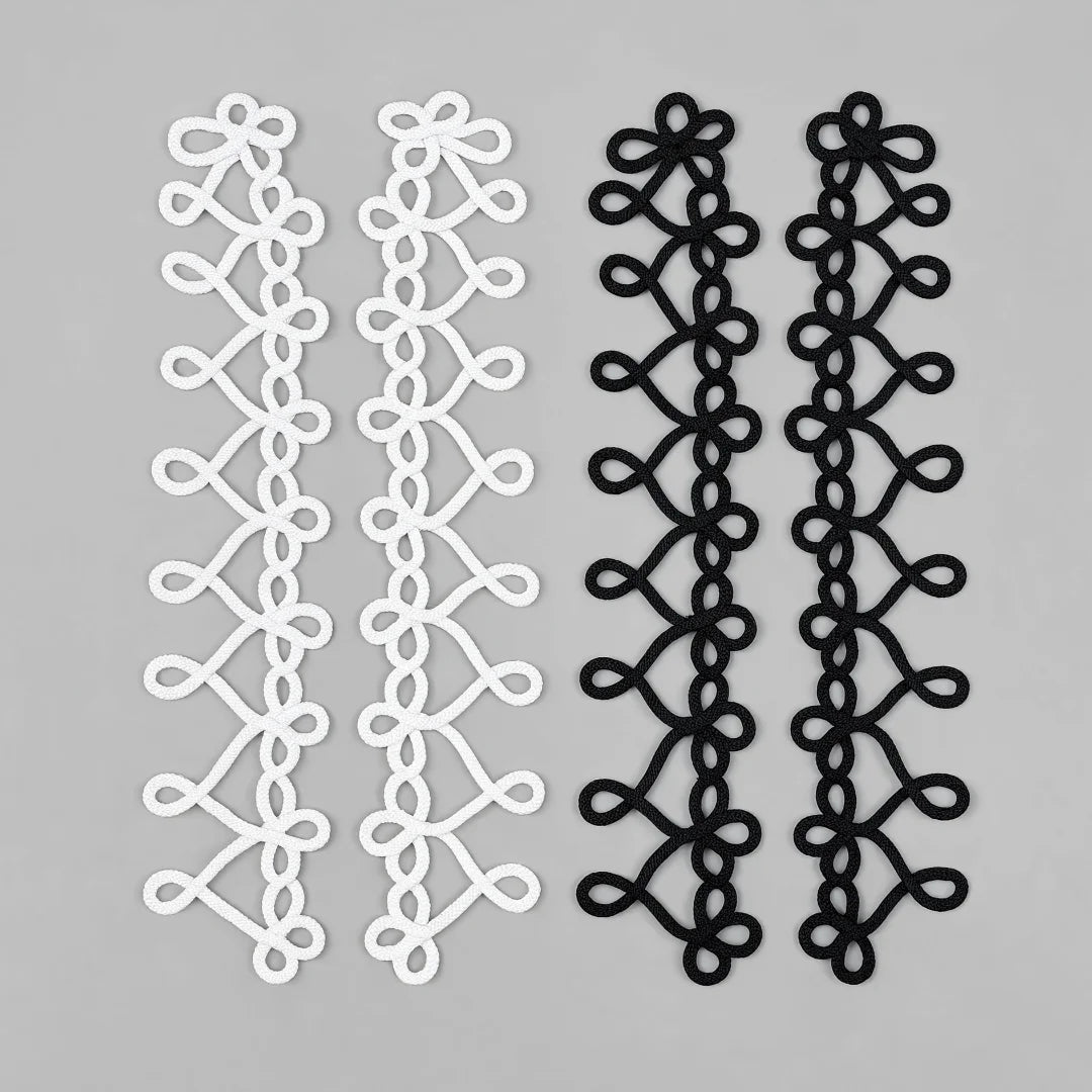 Interlocking heart loop braided cord sew-on patches in white and black, two pairs laid flat on grey background