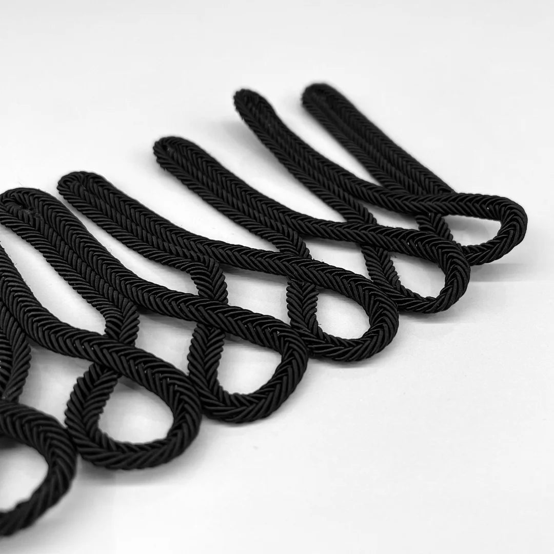 Close-up of black frog closure braid loop Sew-patch showing herringbone braided cord texture and loop detail