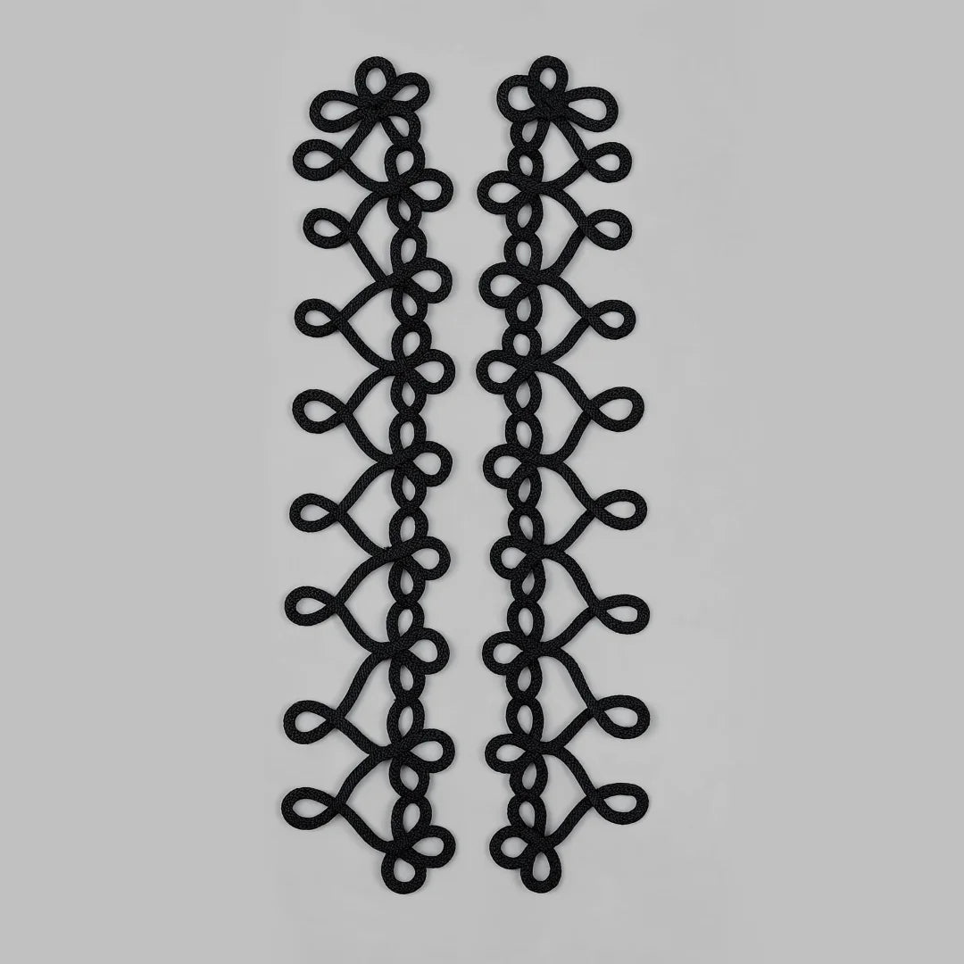 Two long black braided cord trim pieces with a repeating looped floral pattern, displayed vertically on a plain light gray background.