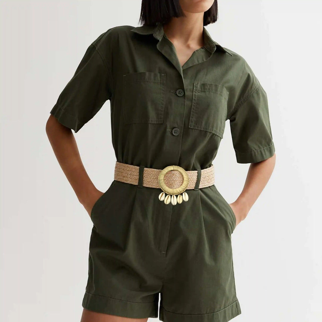 Ani Accessories Beige  Circle Raffia hanging shell buckle belt on a model wearing with a olive green shorts jumpsuit. 