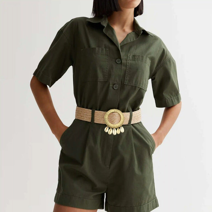 Ani Accessories Beige  Circle Raffia hanging shell buckle belt on a model wearing with a olive green shorts jumpsuit. 