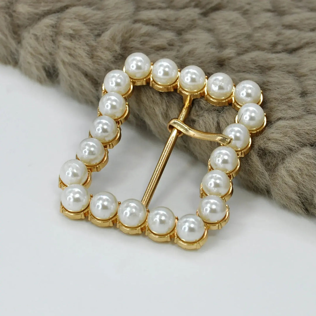 Ani Accessories Gold Finish Shiny Pearl Uneven Shape Prong Buckle  on the placing on the floor in a white background.