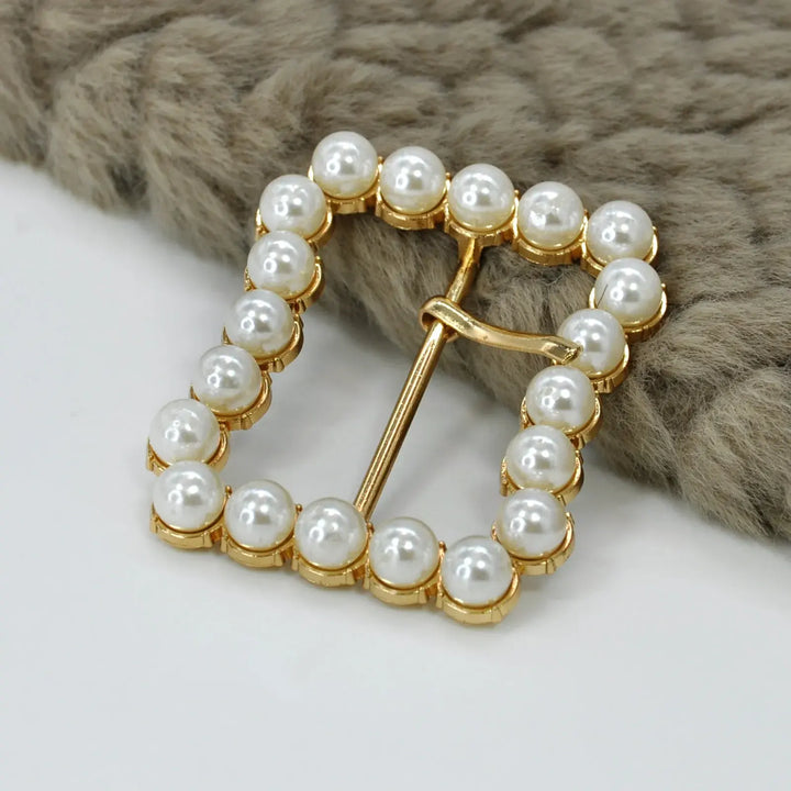 Ani Accessories Gold Finish Shiny Pearl Uneven Shape Prong Buckle  on the placing on the floor in a white background.