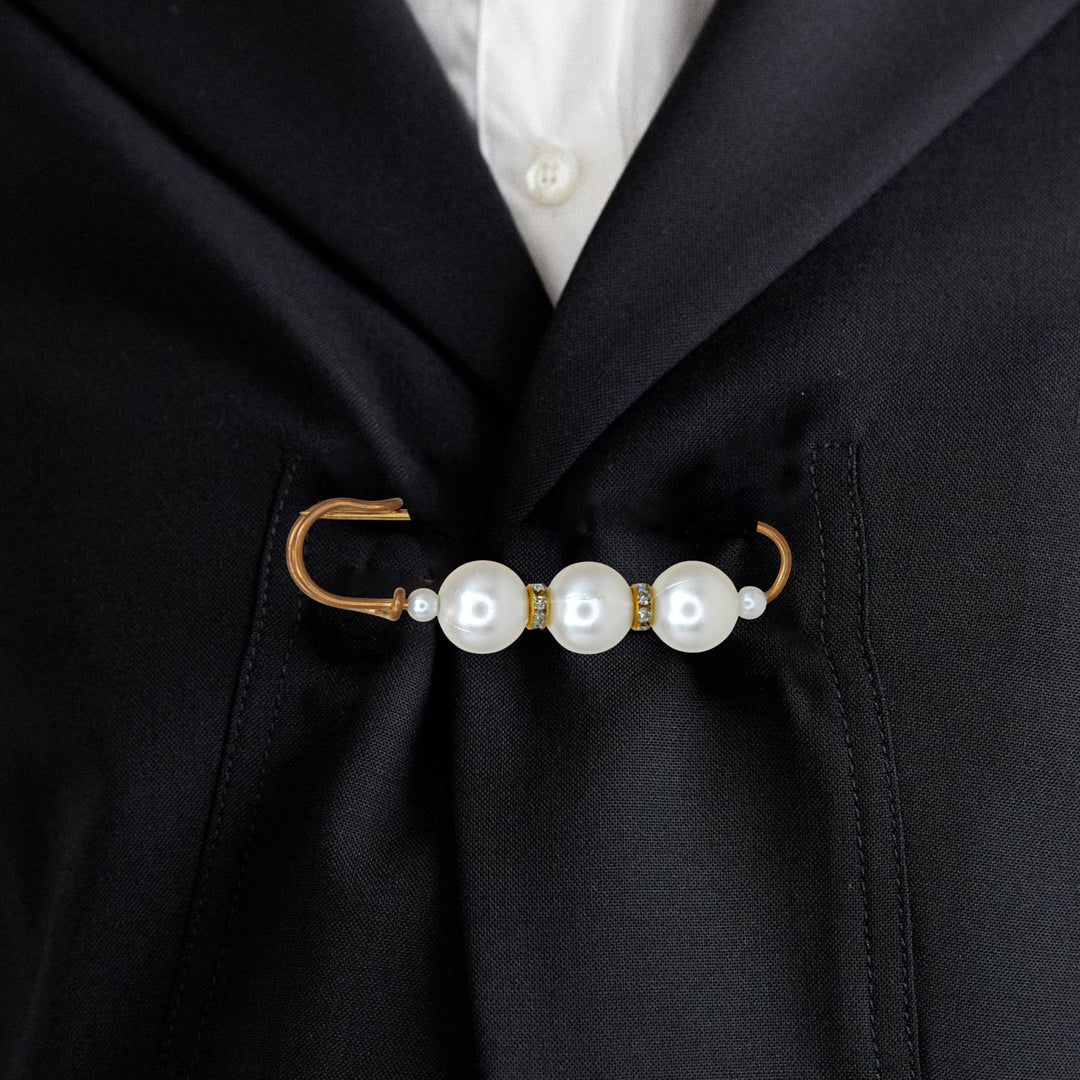 Ani Accessories Pearl brooch safety pin on a black blazer with a white shirt underneath