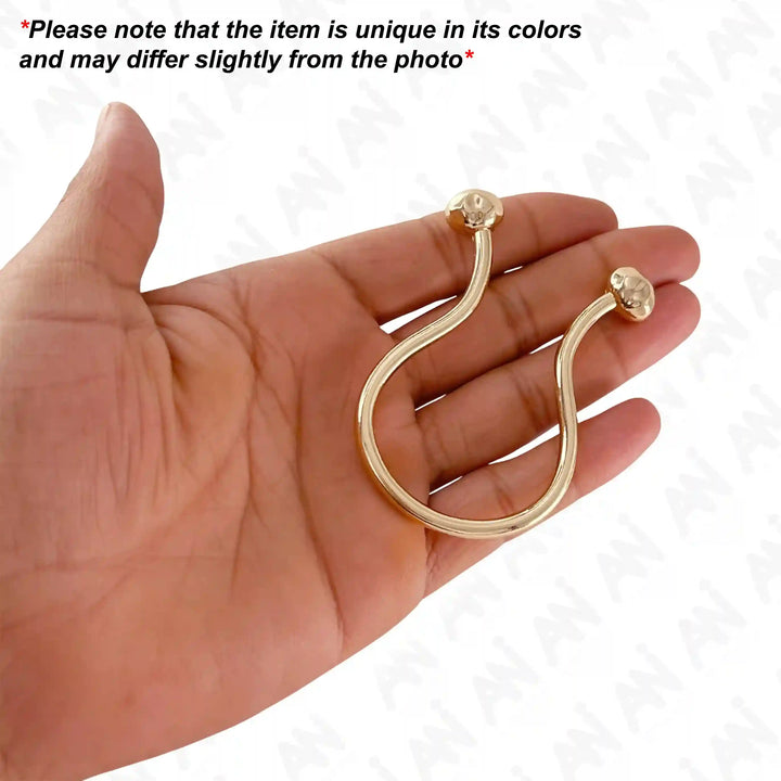 Ani Accessories Refined Curved Gold Metal Buckle placed on the palm of the hand to show the size with caution written on the white background that product may slightly differ from the image.