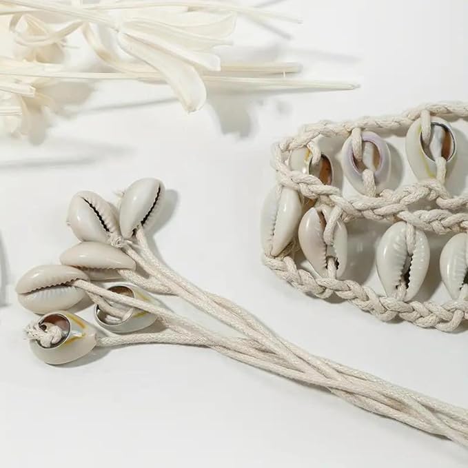 Ani Accessories Womens Belt Beige shell macrame belt worn high over a black dress. Long tassels tied at the waist, ending in cowrie shell clusters.