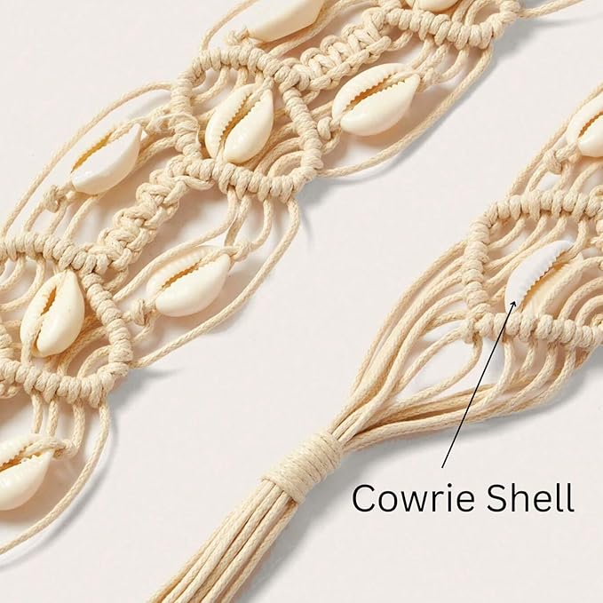 Ani Accessories Womens Belt Boho beige macrame belt with woven cowrie shells, tied in a decorative bow. Styled with tropical leaves in the background.