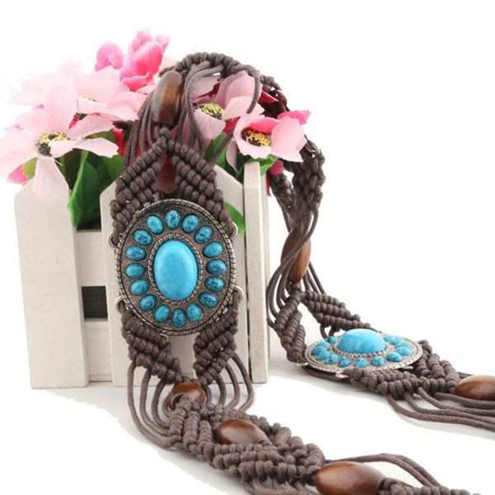 Ani Accessories Womens Belt Front view of a dark brown macrame belt with three central oval turquoise-colored stone medallions and small wooden beads, on flower stand
