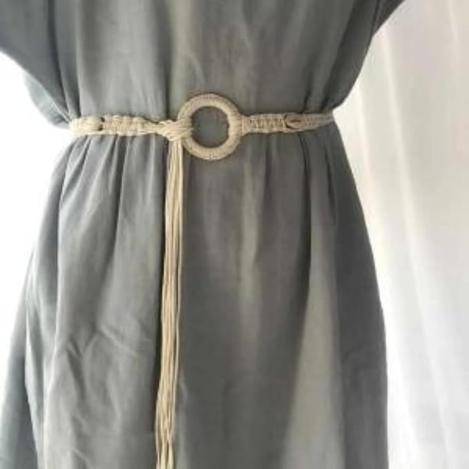 Ani Accessories Womens Belt Full view of a beige macrame belt with cowrie shells and large woven ring buckle on a white background. Ends have blue and wood beads.