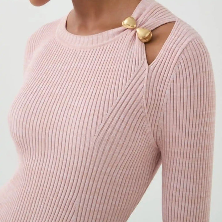 Ani Accessories dual drop design metal gold buckle zooming on the Shoulder of the baby pink knitted top in a white background.