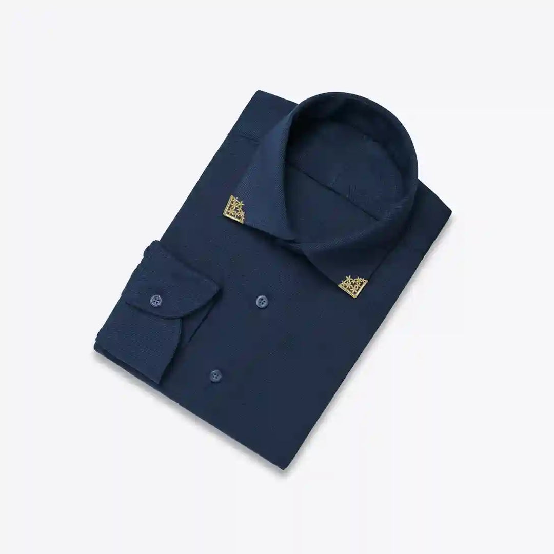 Ani Accessories | Gold Floral collar tip on a folded navy blue shirt.