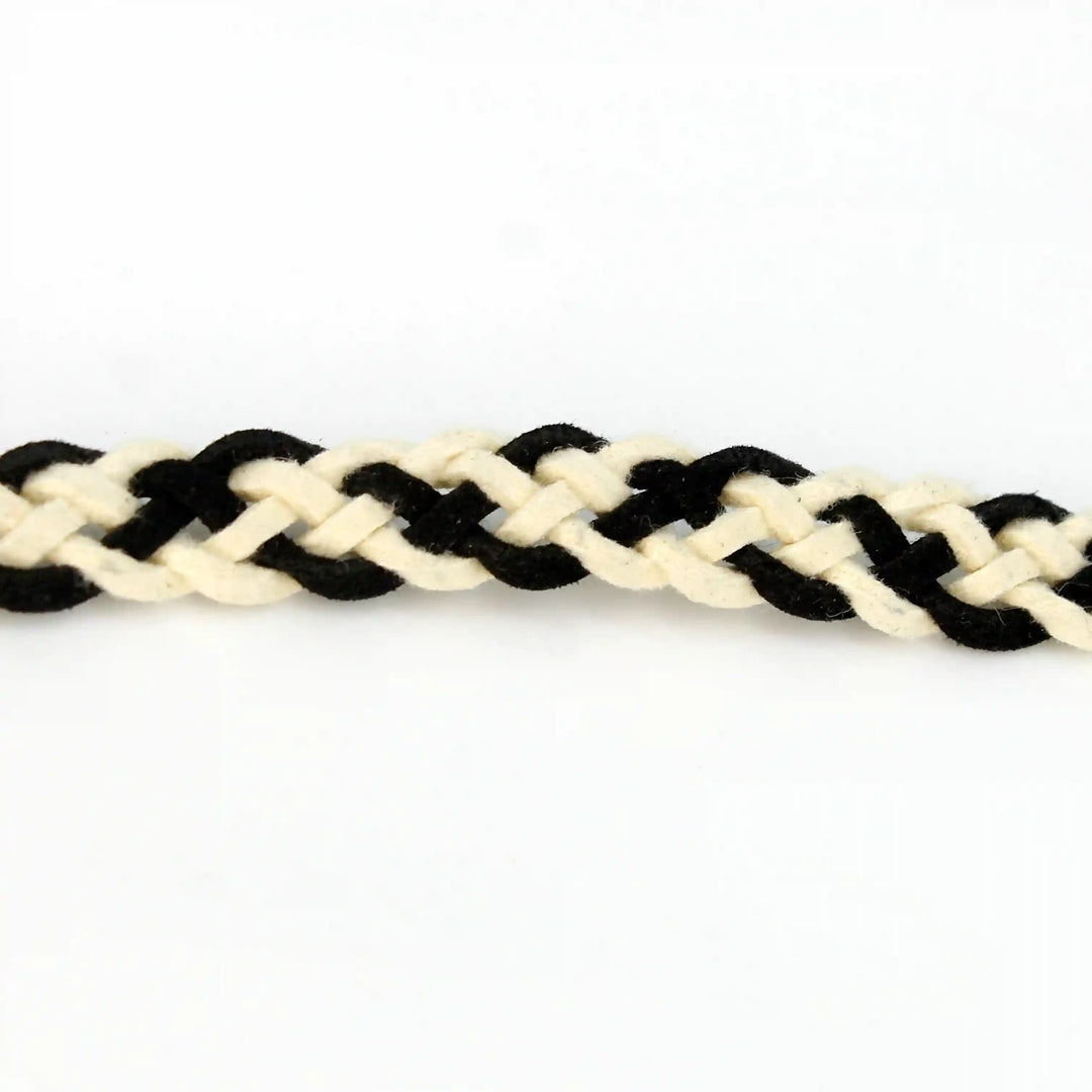 Ani Accessories suede belt. This braided belt is crafted from black and white suede, showcasing detailed braiding on a white background.