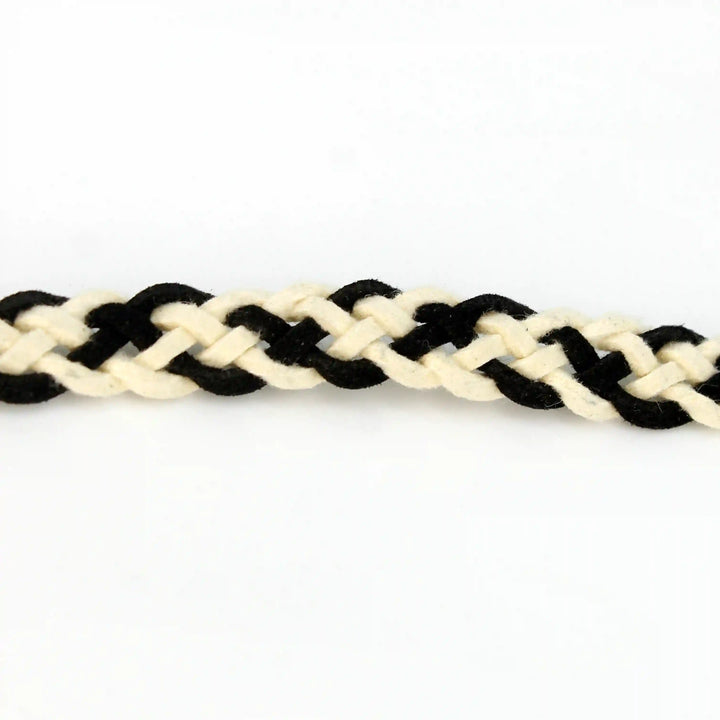 Ani Accessories suede belt. This braided belt is crafted from black and white suede, showcasing detailed braiding on a white background.