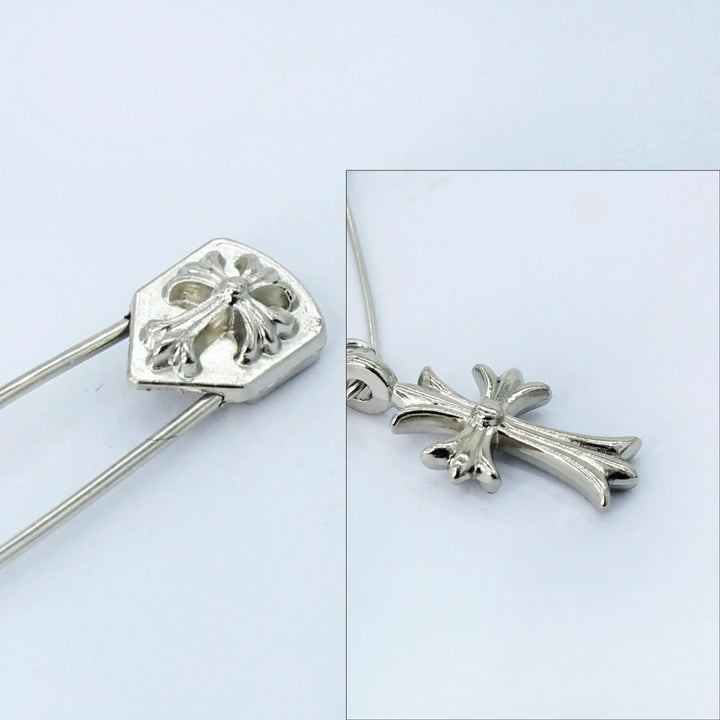 Close-up view of Ani Accessories cross silver safety pin on a white background for clear detailing.