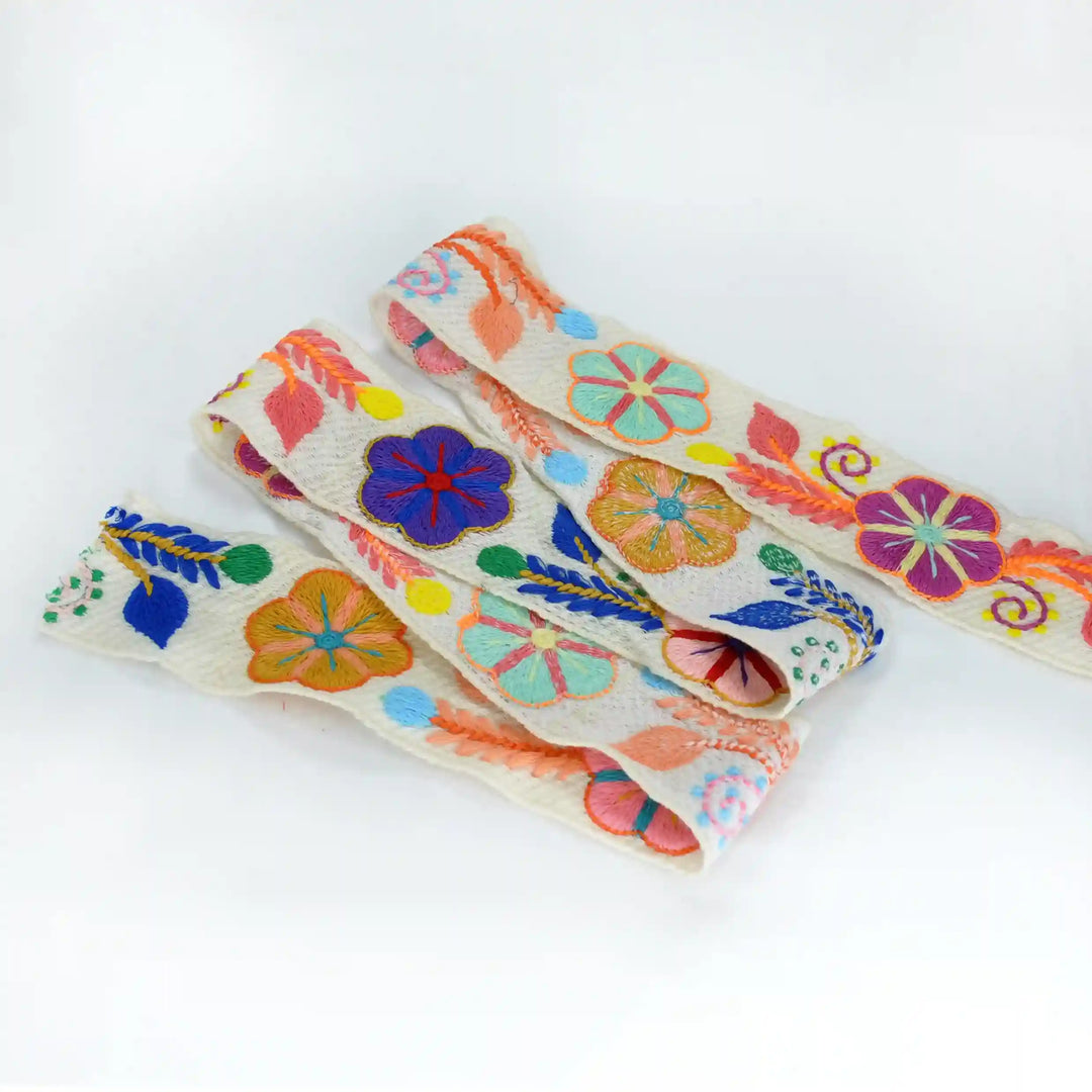Colorful floral-patterned crochet lace on a white background