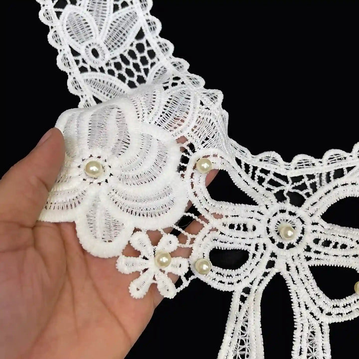 Large bow and flower design neckline close up showing intricate embroidery texture and elegant detailing, dyeable sew-on applique