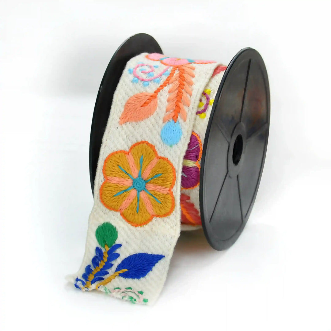 Spool of hand embroidered style crochet lace with colorful floral patterns on a white background | Ani Accessories