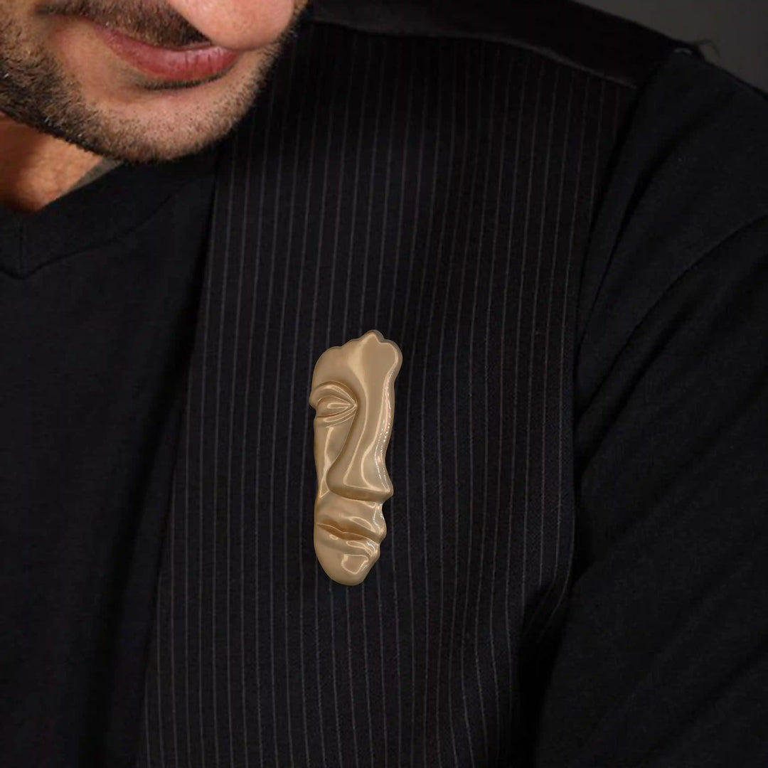 ANI Accessories abstract face brooch pinned on the chest of a black shirt