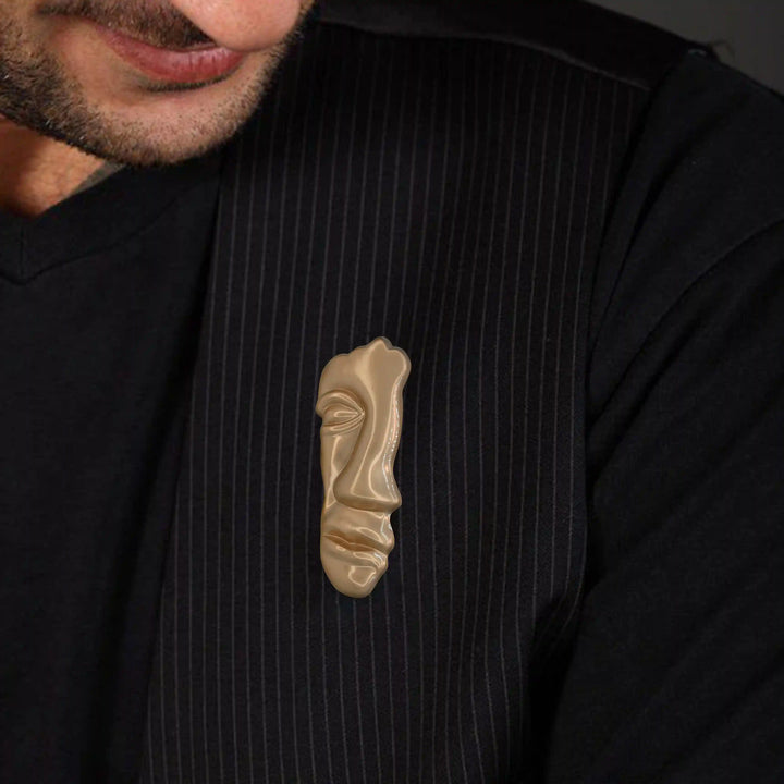 ANI Accessories abstract face brooch pinned on the chest of a black shirt