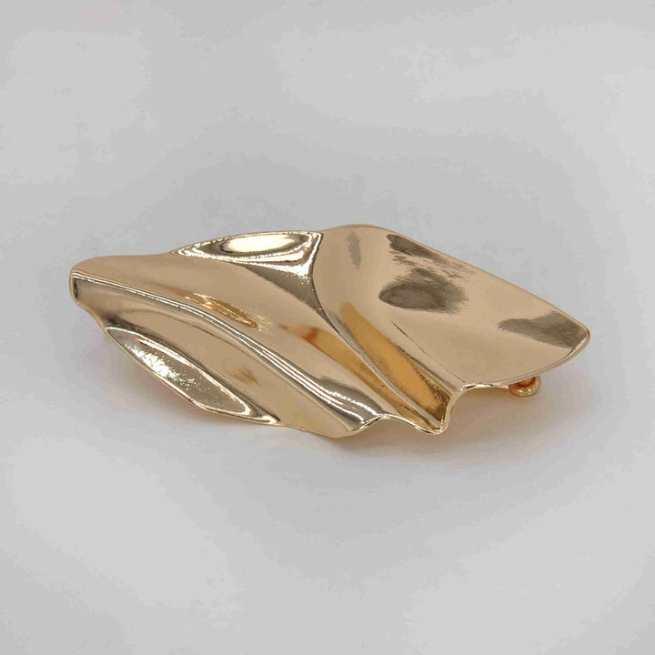ANI Accessories abstract leaf metal buckle in high-shine gold with sculpted waves, on grey color background 