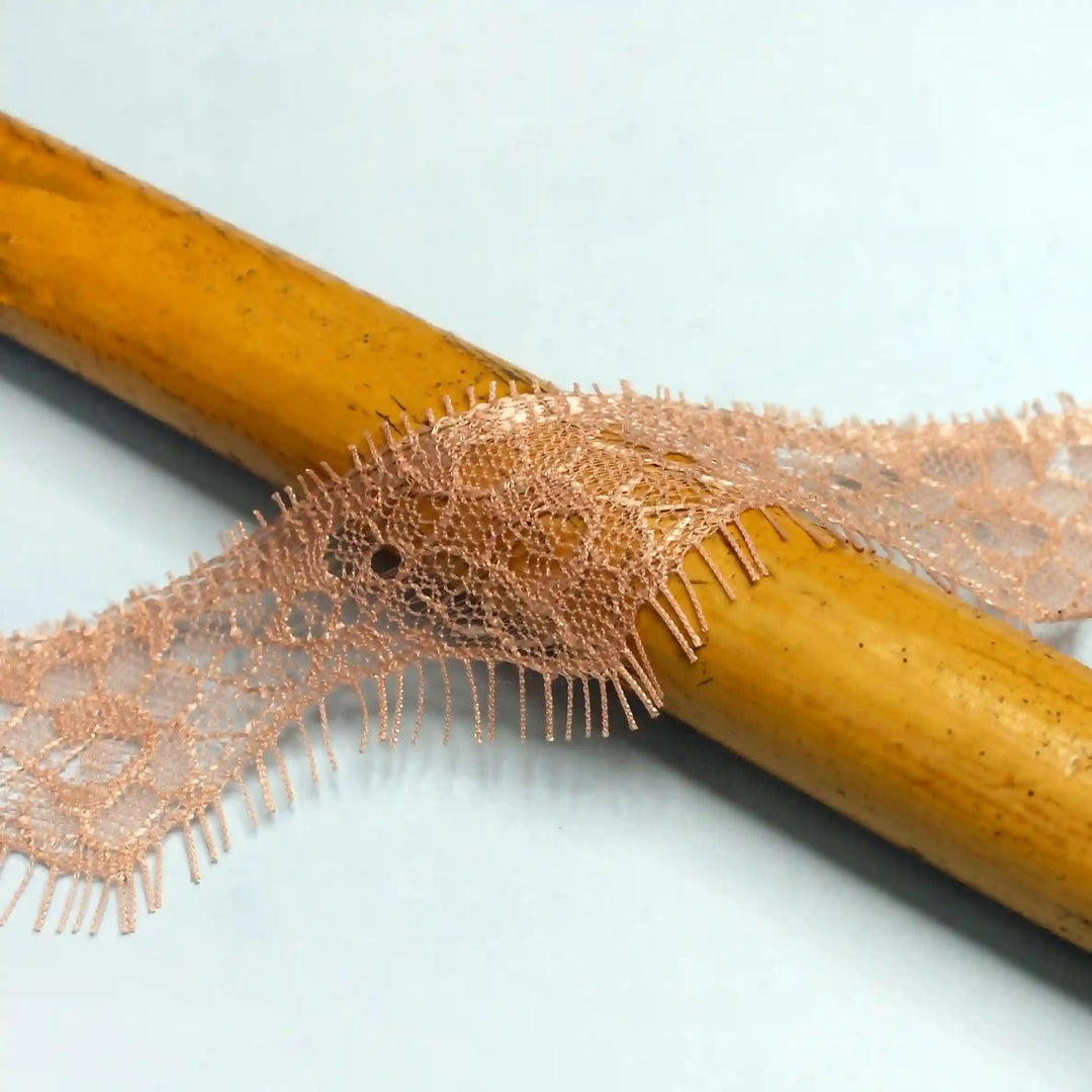 Buy now Peach Eyelash Trim Lace Fabric by Ani Accessories on a wooden surface showcasing its delicate texture