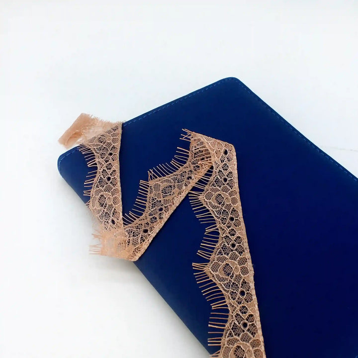 Buy now Peach Eyelash Trim Lace Fabric from Ani Accessories on a blue surface for crafting and decoration