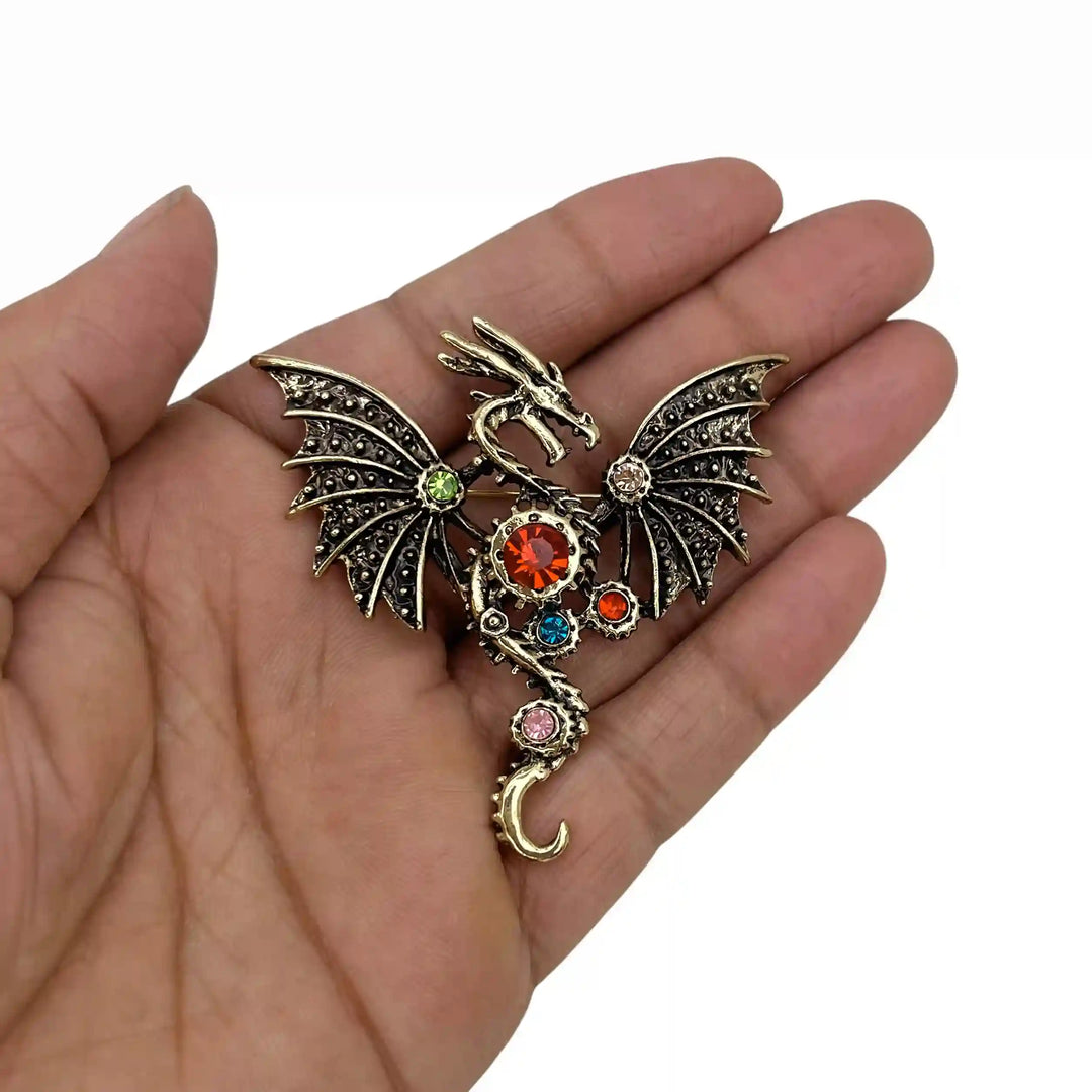 ANI Accessories antique gold dragon brooch held in hand to show its size with white color background 