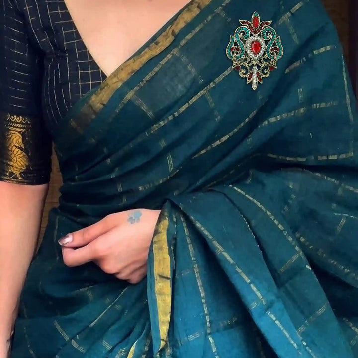 ANI Accessories baroque brooch pinned on the pallu of a teal silk saree 