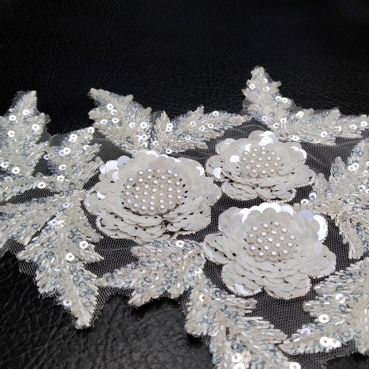 ANI Accessories close-up of sequin flowers with pearl bead centres on a white beadwork patch 