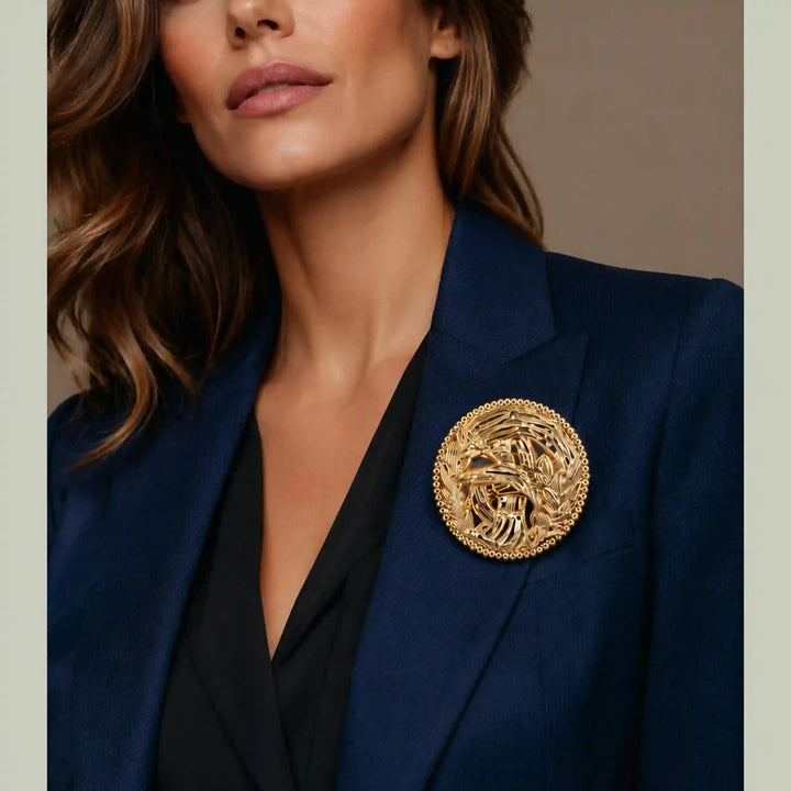 ANI Accessories big gold brooch for women pinned on a navy blue blazer 