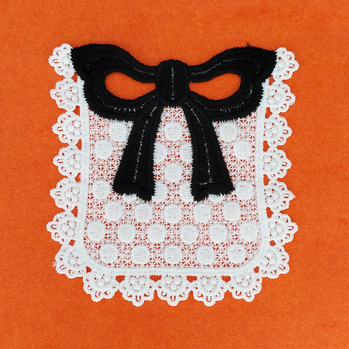 ANI Accessories close view of the black bow and white dotted pocket patch on orange