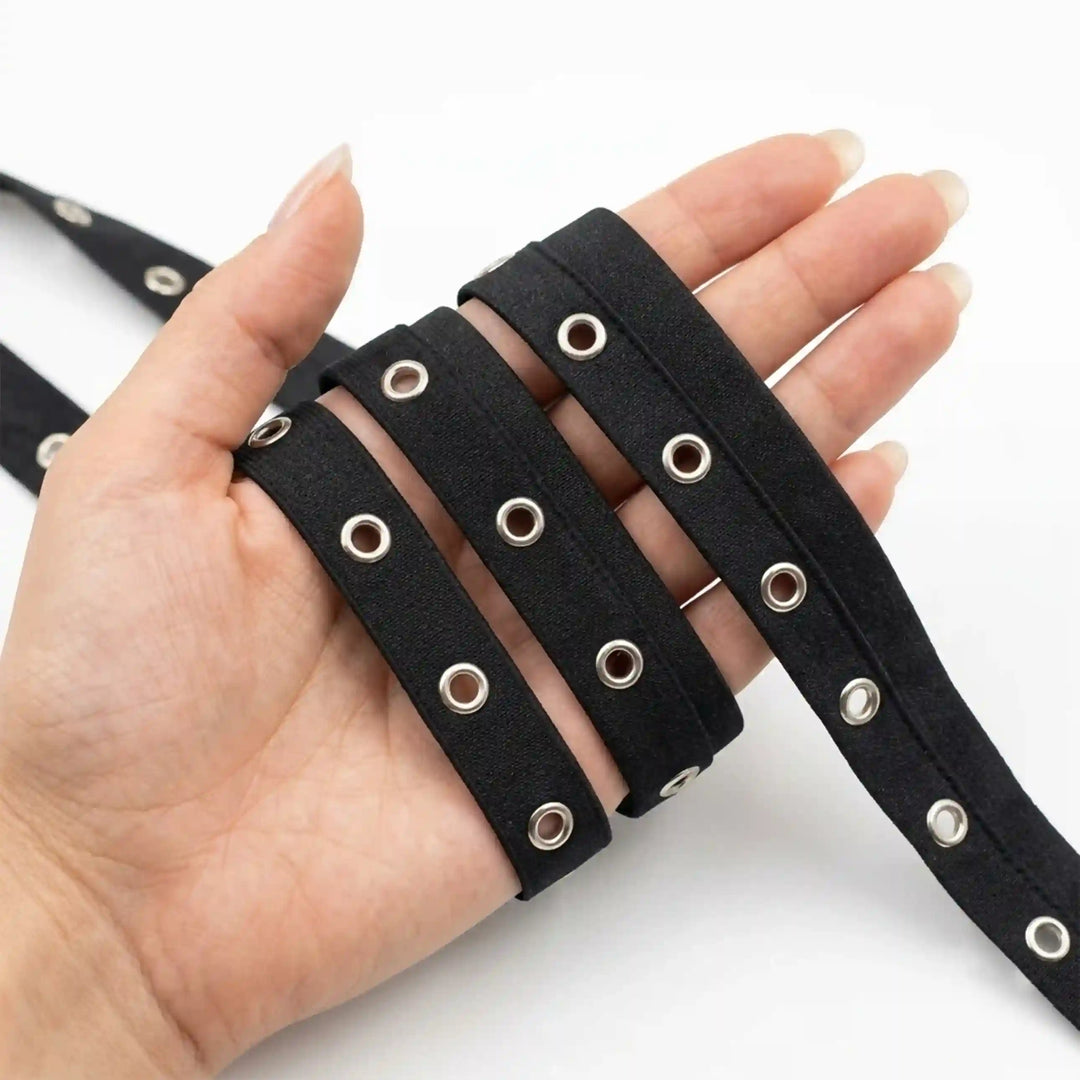ANI Accessories black grommet tape held in hand next to the roll with white color background 