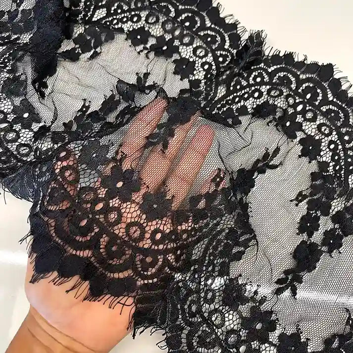 ANI Accessories black lace for blouse sleeves held in hand to show the sheer net with white color background 