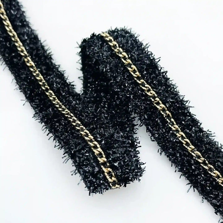 ANI Accessories close-up of shiny black lurex strands and gold chain with white color background 