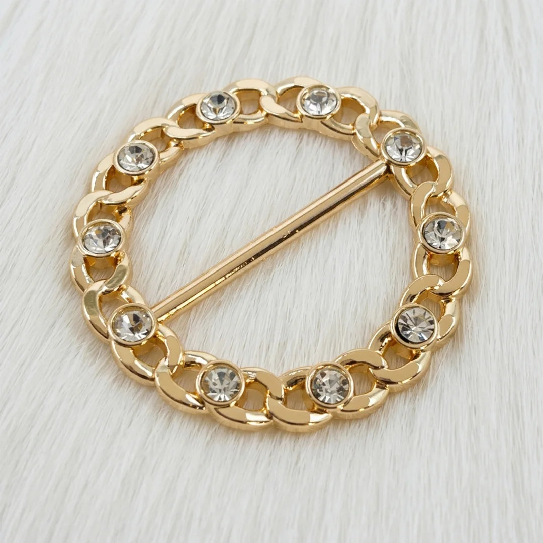ANI Accessories round gold chain link rhinestone belt buckle, angled view of curb links and bezel-set stones on white fur