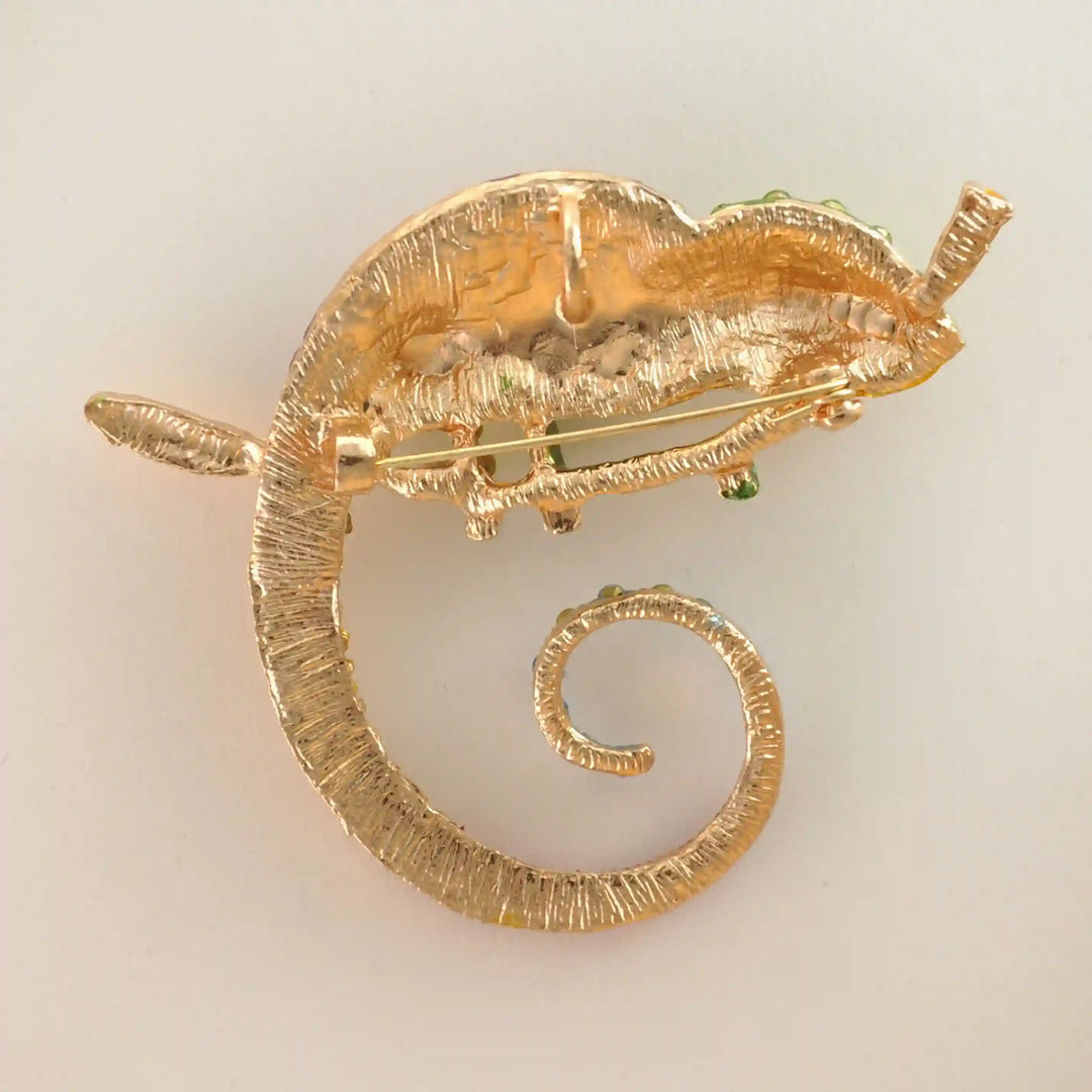Back side of the chameleon brooch showing the gold base and brooch pin with white color background 