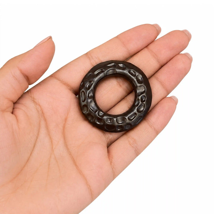 ANI Accessories dark brown hammered O-ring buckle resting in an open palm to show real size, on white with white color background 