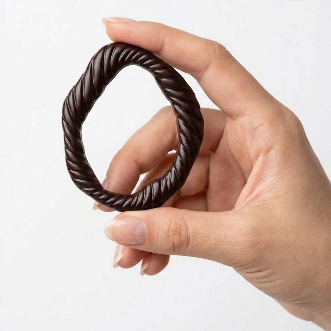 ANI Accessories dark brown twisted rope ring buckle held upright between fingers to show real size, on white background 