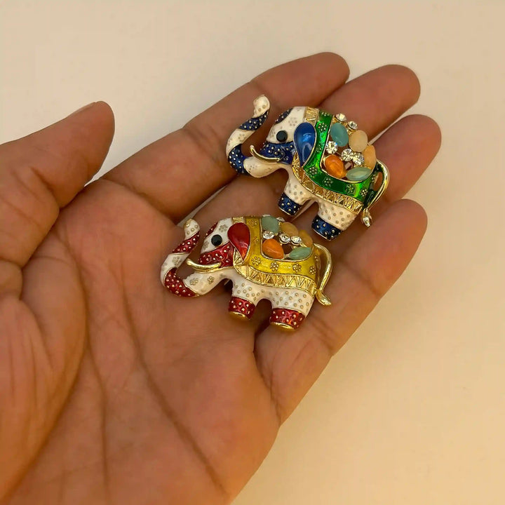 ANI Accessories yellow and green elephant brooches held in hand to show their size 