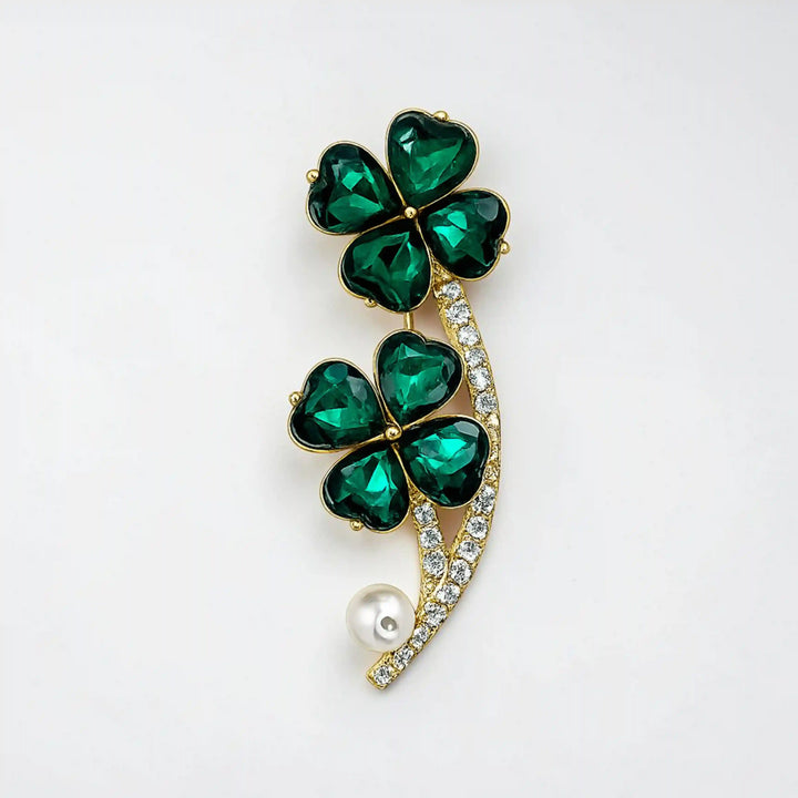 ANI Accessories four leaf clover brooch with emerald green crystals and white pearl, front view on white 