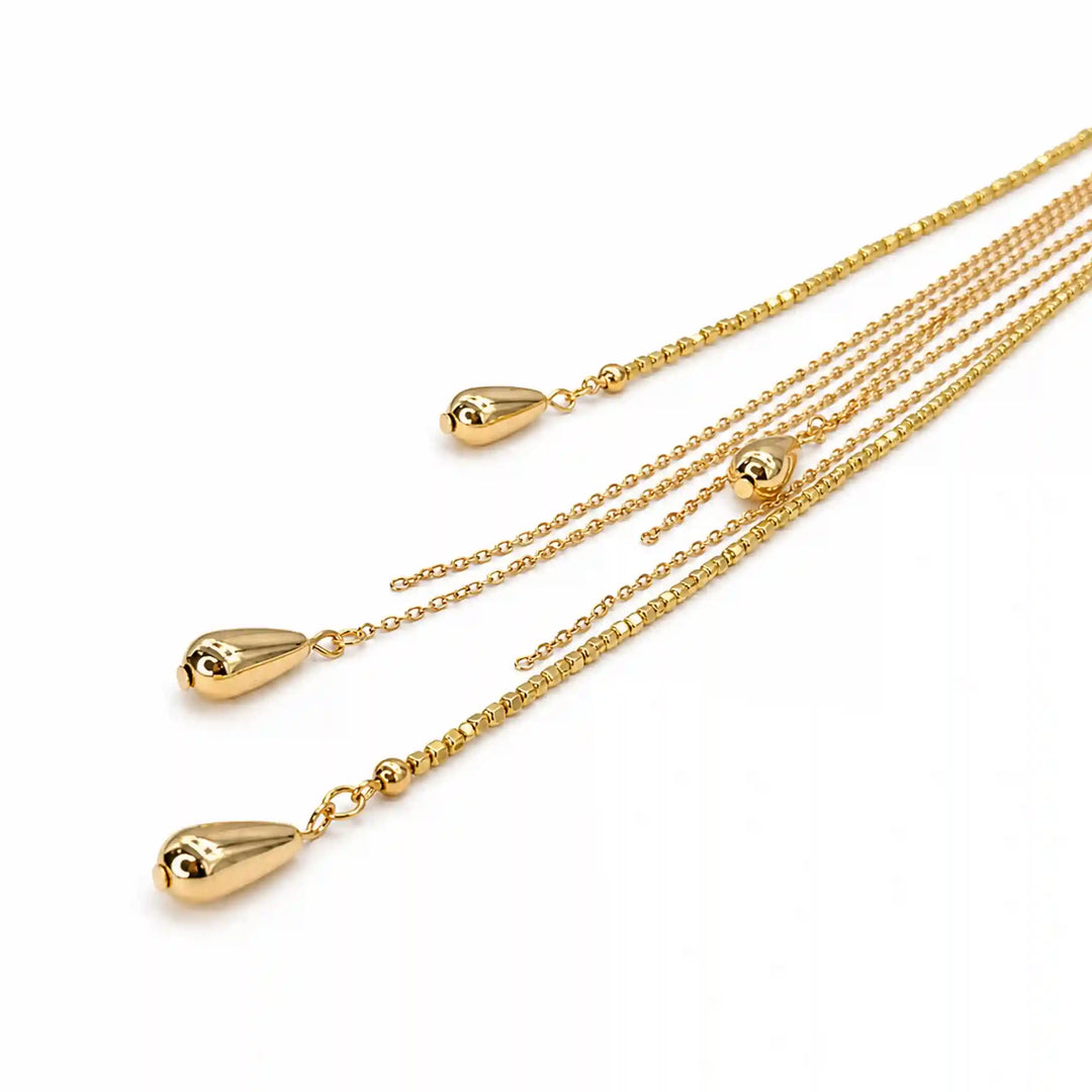 ANI Accessories gold chain tassel brooch close-up showing the polished teardrop drops with white color background 