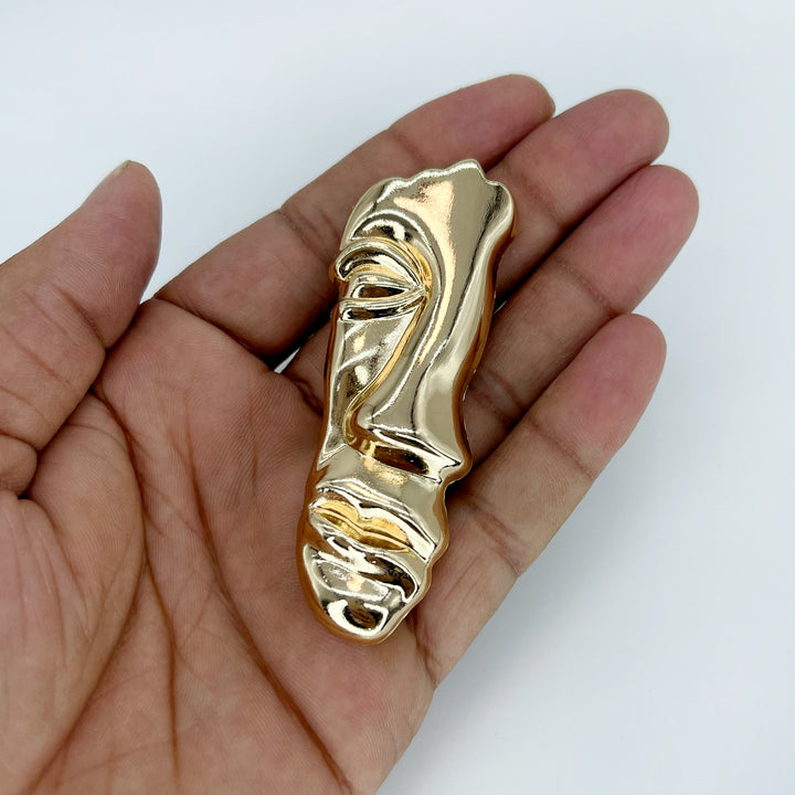 ANI Accessories gold face brooch with high-shine sculpted face, front view on white 