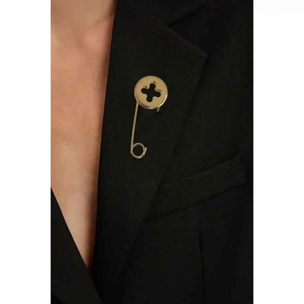 ANI Accessories gold kilt pin brooch worn on the lapel of a black blazer 