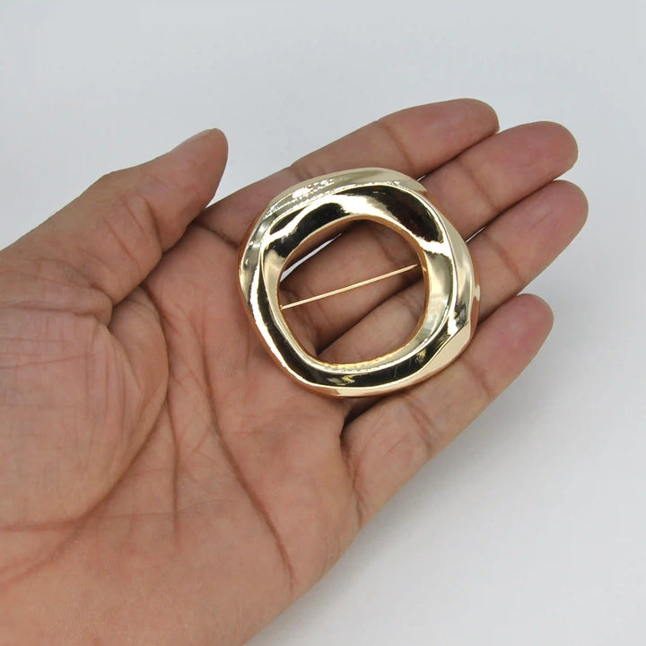 ANI Accessories gold open circle brooch held in hand to show its size 