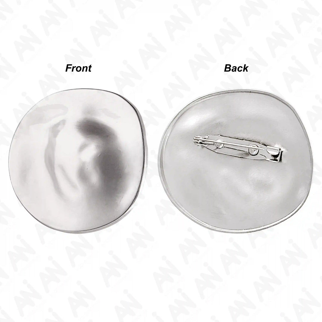 ANI Accessories gold round metal brooch with a rippled, crater-like surface color background 