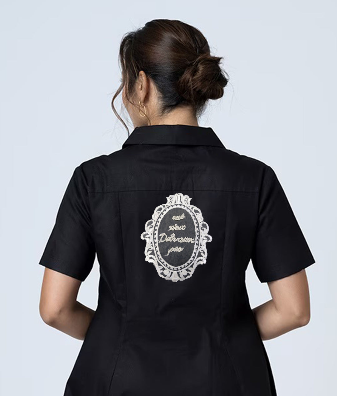 ANI Accessories large embroidered patch stitched on the centre back of a black dressb 